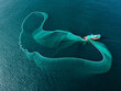 © AmazingAerialAgency - Aerial view of a fishing boat amidst the vast, deep blue sea, casting a wide net like a shimmering emerald veil across the water, An Ninh Dong, Phu Yen, Vietnam.
