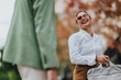 © qunica.com - A cheerful woman in a white shirt and sunglasses chats outdoors, carrying a bag during autumn. Bright, friendly scene suitable for topics like collaboration, daily work, and travel.
