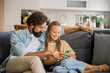 © Westend61 - Father and child laughing together using mobile phone on couch