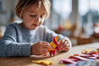 © Jane_S - Young caucasian child engaged in colorful origami crafting activity indoors