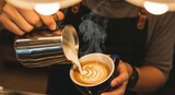 Barista pouring milk into coffee cup to create latte art.