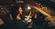© Wess/peopleimages.com - Singing, driving or happy woman in car at night, listening to radio or dancing for travel entertainment. Transport, music playlist or driver with sound system for fun, dark road or trip in vehicle