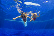 © Tropical studio - Happy family - mother, baby girl in goggles swim, dive in pool with fun - jump deep down underwater. Healthy lifestyle, people water sport activity, swimming lessons on holidays with kids