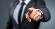 © sornram - An assertive business professional points forward, exuding confidence and leadership in a modern setting.