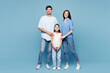 © ViDi Studio - Full body young smiling lovely cheerful happy parents mom dad with child kid daughter girl wearing casual clothes stand hug look camera isolated on plain blue background. Family day childhood concept.