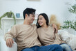 © Washburn - Happy couple laughing on the sofa and watching TV drama online