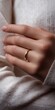 © Andrii Zastrozhnov - Close-up of female hand with gold wedding ring on white sweater background