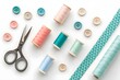 © IrenKa - Flat lay of colorful sewing supplies including pastel threads, buttons, scissors, and patterned fabric on white background for creative projects