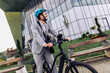 © Mediteraneo - Young businessman riding an electric bike to work, wearing a professional suit.