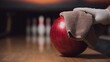 © Vagner Castro - Close-up of hand cleaning red bowling ball with cloth, ball in return area, motion and care in crisp detail.