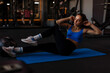 © Home-stock - Sporty woman doing bicycle crunch sit up exercise on mat in gym, training abs core muscles, having morning workout in sports club