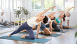 © JackF - Adult woman doing pilates on mat in female group in studio