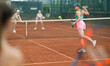 © JackF - Young woman playing tennis against elderly women on tennis court