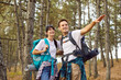 © Studio Romantic - Happy hikers couple with backpacks trekking on forest trail. People walk, carrying mats and gear, enjoying travel and nature. Outdoor exploration, adventure on weekend, and hiking concept.