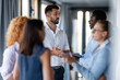 © Zoran Jesic - Business professionals networking and discussing ideas in modern office hallway