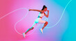 © Prostock-studio - A female athlete is captured mid-air, demonstrating a powerful jump while skipping rope against a vibrant pink and blue background. The scene emphasizes energy and fitness.