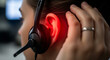 © Firyal Affina - Red ear pain from headset. Person experiencing discomfort, fatigue, or hearing issues from prolonged use in a call center or office.