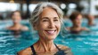 © Thamonchanok - Senior women enjoying group swimming class in pool concept. Cheerful woman enjoying aquatic exercise in a tranquil pool.