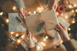 © oatawa - Hands exchanging Christmas gift box wrapped in brown paper with pine decoration and red white string, festive holiday season celebration with warm lights, friendship and happiness in home, New year