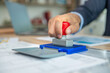 © BESTIMAGE - A person stamping a document with a red stamper