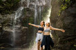 © Apichat - Happy young women hiking enjoying freedom at waterfall