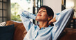 © PeakCC/peopleimages.com - Smile, stretching and woman with relax on sofa for weekend break, peaceful morning and mindfulness. Calm, mature person and happy with resting in home for stress relief, daydreaming and comfortable