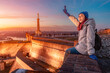 © EdNurg - Young woman smiling and waving at sunset, observing Belgrade city skyline from Kalemegdan Fortress