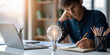 © Tanakorn - Focused business man writing creative idea for project. glowing lightbulb as an ai agent symbolizes innovation and solution for studying complex strategy