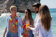 © NDABCREATIVITY - Group of young friends having fun at the beach with colorful drinks, laughing in the sun at summer