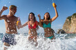 © NDABCREATIVITY - Group of young friends having fun at the beach with colorful drinks, laughing in the sun at summer