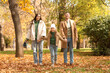 © Pixel-Shot - Happy parents with their little daughter holding hands in autumn park