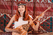 © EdNurg - Young woman musician wearing traditional Kyrgyz clothing playing komuz, a three stringed fretless lute, inside a yurt