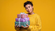 © Tatiana - A woman is holding three boxes of gifts and smiling