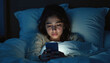 © Vadym - Young woman in bed at night uses phone. She looks tired upset. Girl scrolls mobile device under blanket in dark room. Social media addiction concept.