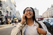 © Westend61 - Smiling woman talking on mobile phone in city street on a sunny day