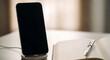 © inktrek - Smartphone on wireless charger with notebook