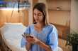 © Svitlana - Woman patient using smartphone while seated in hospital clinic
