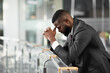 © Prostock-studio - Overwhelmed young black businessman feeling down after business meeting, standing by railing, touching his head, panorama with copy space, side view. Difficulties with business concept