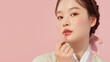 © Broccolini - korean woman applying lip tint in pastel hanbok, cosmetic model