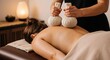 © D-point - Woman receiving a back massage with herbal compress balls at a spa salon. Aromatherapy and traditional thai treatment for relaxation and wellness.