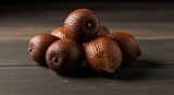 Salak or snake fruits arranged in a pyramid on dark wooden surface