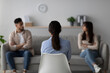 © Prostock-studio - In a therapy session, a female psychologist is assisting a quarreling middle eastern couple. The scene captures the back view of the psychologist as she guides the couple toward resolution.