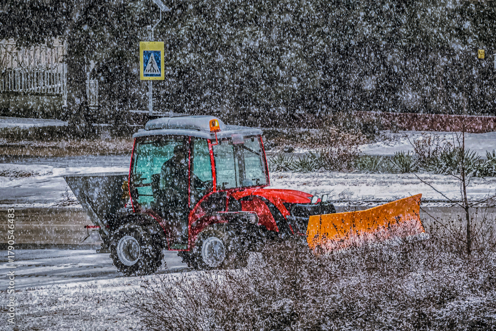Snow plow tractor working during heavy snowfall in winter city street ...