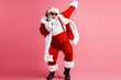 © deagreez - Santa performs on stage in a red suit with white fur singing into a microphone against a pink background creating a fun festive moment for holiday lovers