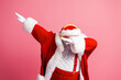 © deagreez - Santa in red suit dabbing pose against pink background capturing festive mood relaxed smile and holiday joy