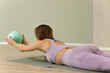 © zhagunov_a - Woman doing pilates exercise with fitness ball indoors