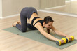 © zhagunov_a - Woman doing fitness exercise with dumbbells on mat