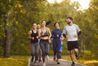 © Studio Romantic - Group of runners jogging in park, physical exercises and healthy activity of young happy people in morning. Smiling athletes run, enjoy running workout with friends team, boost fitness motivation