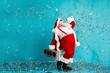 © deagreez - Santa with boombox lights up blue backdrop with confetti for Christmas season celebration and holiday promotion