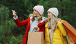 © rohappy - Christmas happy young two women friends taking selfie with smartphone, girlfriends together